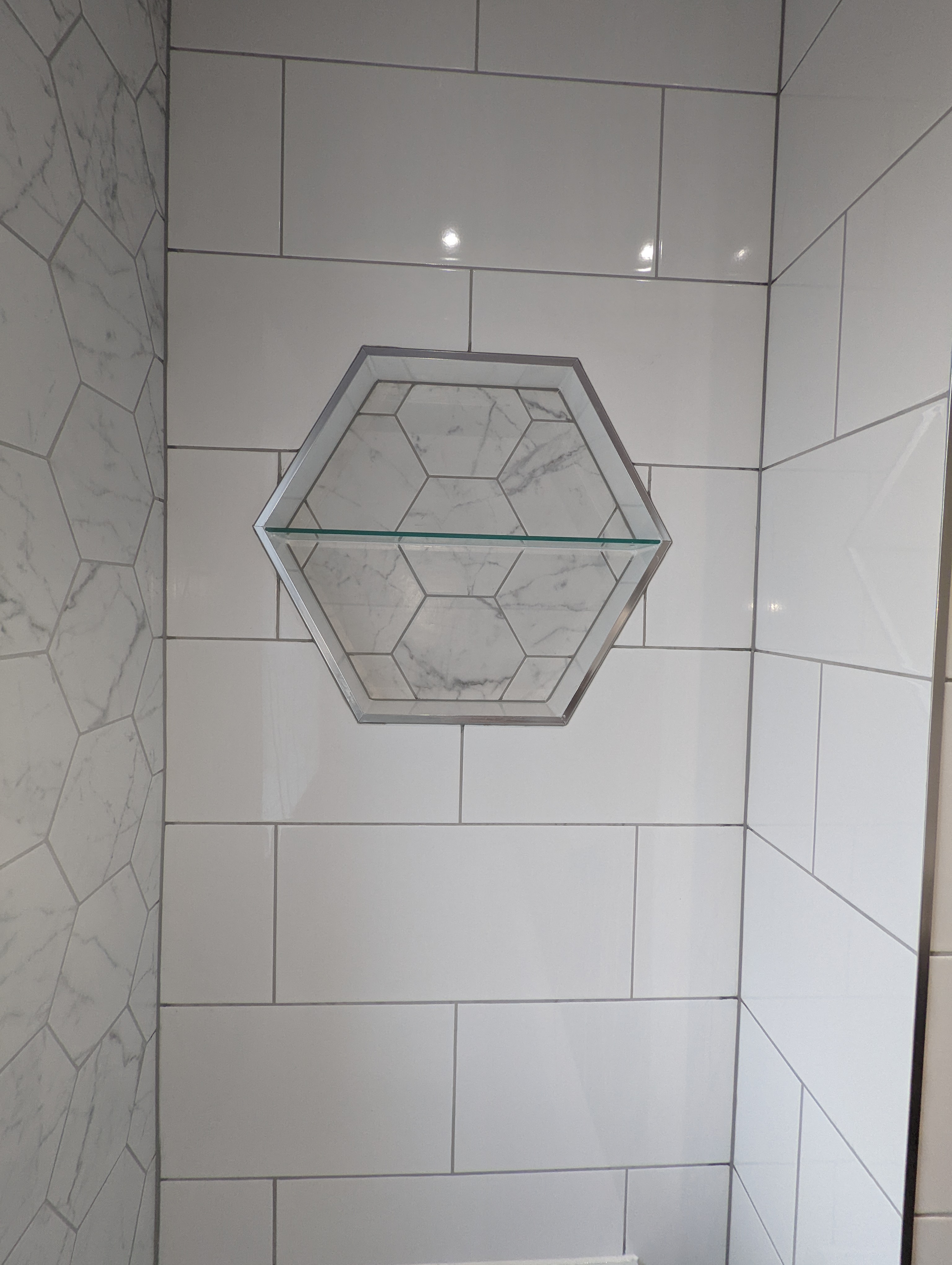 This hexagonal tiled recess was an interesting one to complete. The glass shelf was also reused from the old bathroom, a small but nice touch. 